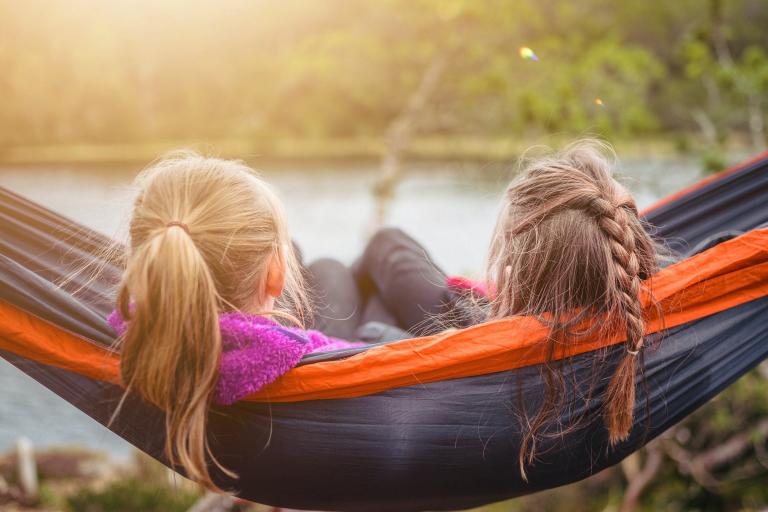 image shows two girls in a hammock